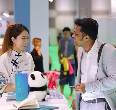 Attendee chatting friendly with a booth hostess at Vitafood Asia