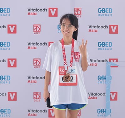 5k Run participant posing at the photo booth with their medal